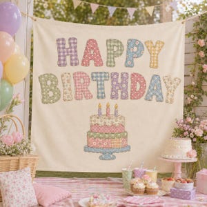 May include: A cream-colored fabric banner featuring the text HAPPY BIRTHDAY in multi-colored, patterned, fabric-appliqued letters. Below the text is a graphic of a three-tiered cake with candles, also rendered in patterned fabric applique.