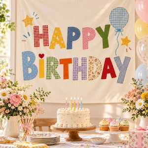 May include: A cream-colored fabric wall hanging featuring the text HAPPY BIRTHDAY in multi-colored, patterned fabric letters. The banner is decorated with fabric stars and a blue gingham balloon. It is displayed above a birthday cake.
