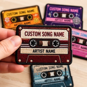 May include: A rectangular embroidered patch shaped like a vintage cassette tape with a dark red and cream color scheme. The text CUSTOM SONG NAME and ARTIST NAME are stitched in black and red thread. The design features two circular spools.