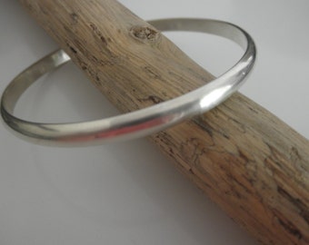 May include: A silver bangle bracelet with a smooth, polished finish.