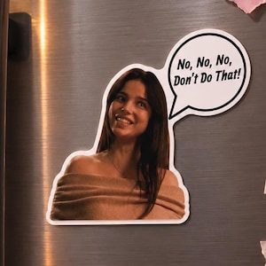 May include: A die-cut vinyl sticker featuring a woman with long dark hair wearing a tan off-the-shoulder top. A white speech bubble extends from the right side of the sticker, containing the black text: No, No, No, Don't Do That!