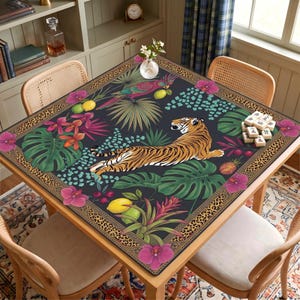 May include: A square table cover featuring a dark background with a central tiger illustration, surrounded by tropical foliage, pink orchids, lemons, and a parrot. The border has a leopard print pattern, and a small stack of mahjong tiles sits on top.