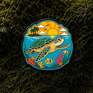 Puede incluir: Una pegatina circular que muestra una tortuga marina verde nadando en agua azul. La escena incluye un sol amarillo, nubes blancas, palmeras en una pequeña isla, un pez payaso, un pez ángel amarillo, una estrella de mar y arrecifes de coral.