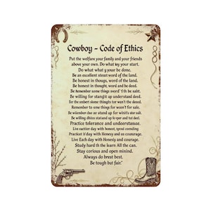 Può includere: Una targa rettangolare in metallo con sfondo color crema invecchiato che riporta il testo Cowboy - Code of Ethics. Il bordo ha una finitura marrone ruggine con illustrazioni di un ferro di cavallo, una stella, una pistola e uno stivale.