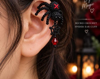 May include: A black micro crochet spider ear cuff featuring a red stitched cross on the spider's back, a dangling black web charm, and a faceted red crystal bead. The text reads Tiny Stitches Big Magic, MICRO CROCHET SPIDER EAR CUFF, and WonderGroveLearning.