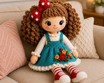 May include: A handcrafted crochet doll with curly brown yarn hair, wearing a red polka-dot bow, a white long-sleeved shirt, and a teal overall dress featuring embroidered red and yellow flowers. The doll wears white and red striped socks and red shoes.