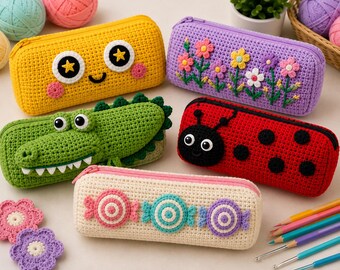 May include: Five rectangular crochet pencil cases featuring various designs: a yellow case with a smiling face, a purple case with floral embroidery, a green crocodile-shaped case, a red ladybug case, and a cream case with three candy motifs.