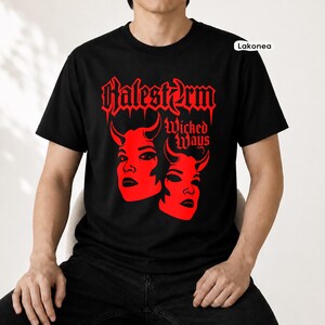 May include: A black short-sleeved t-shirt featuring a red graphic print on the chest. The design displays the text Halestorm and Wicked Ways above two stylized faces with horns. The brand name Lakonea is printed in a small white box in the corner.
