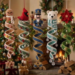 Könnte beinhalten: Fünf hängende Häkelornamente, bestehend aus einem Lebkuchenmann, einem roten Kardinal, einem Nussknacker, einem weißen Eisbären und einer roten Weihnachtssternblüte. Jede Figur ist an einem langen, spiralförmigen Häkelschwanz befestigt.
