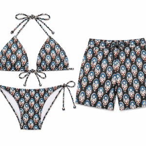 Może przedstawiać: Dopasowany zestaw składający się z trójkątnej góry od bikini z wiązaniami, dołu od bikini z wiązaniami po bokach oraz szortów kąpielowych. Wszystkie elementy mają czarne tło z powtarzającym się kwiatowym wzorem w odcieniach niebieskiego, bieli i rdzy.