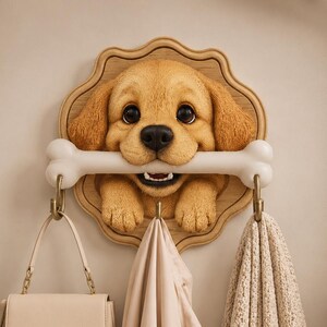 May include: A wall-mounted coat rack featuring a sculpted golden puppy head with large dark eyes, holding a white bone in its mouth. The puppy is mounted on a scalloped wooden plaque. Three metal hooks hang from the bone to hold items.
