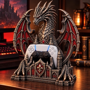 May include: A detailed dragon figurine controller stand featuring a metallic bronze finish with red wing accents. The dragon is perched atop a stone-like base with a central shield emblem, designed to hold a white and black game controller.