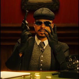 May include: A person wearing a dark gray flat cap, dark sunglasses, a white collared shirt, a gray vest, and a dark blazer. They are wearing black leather gloves and holding a black revolver. In the background, a framed sign displays the text W X HEX.