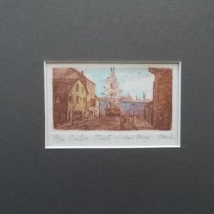 以下が含まれることがあります： 港の風景を描いた芸術的なプリント。高い帆船と水辺に並ぶ建物が特徴です。アートワークは茶色の色調で、青い空と水があります。「33/50 Centre Street - New Burga Beach」の文字が見えます。