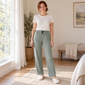 May include: A plain white short-sleeved crew neck t-shirt paired with sage green lounge pants featuring a drawstring waist and straight-leg fit, worn with simple white slip-on shoes.