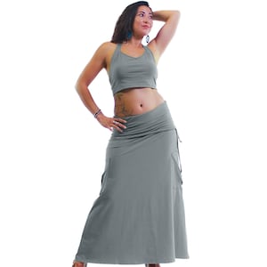 May include: A woman wearing a gray halter top and a long gray skirt. The skirt has a gathered waist and a flowing silhouette.