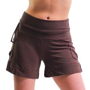 Può includere: Shorts marroni con una cintura larga e tasche. I pantaloncini sono realizzati in un tessuto morbido e confortevole e hanno una vestibilità rilassata.