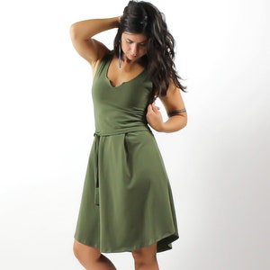May include: A green sleeveless dress with a V-neckline and a tie at the waist.