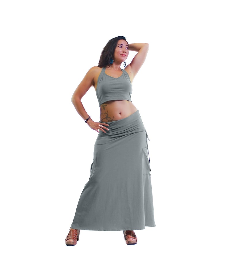 May include: A woman wearing a gray halter top and a long gray skirt. The skirt has a gathered waist and a flowing silhouette.