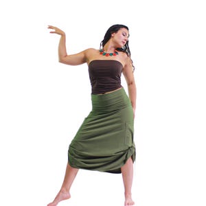 May include: A woman wearing a brown tube top and a long, olive green skirt with a gathered detail at the bottom. She is wearing a multi-colored necklace.