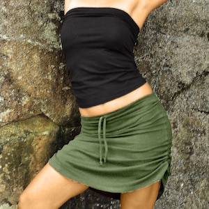 May include: A green, gathered skirt with a drawstring waist. The skirt is made of a soft, comfortable fabric and has a relaxed fit.