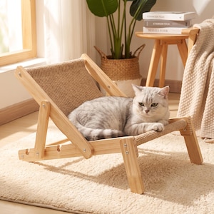 May include: A light-colored wooden pet lounge chair with an adjustable frame and a textured beige fabric seat. A silver-grey tabby cat with green eyes is resting on the seat of the chair, which features a slatted design and metal hardware.