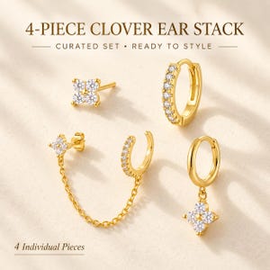 May include: A 4-piece clover ear stack set featuring gold-tone earrings with clear stones. The set includes a clover stud, a pavé hoop, a double-piercing chain earring with a clover stud and pavé cuff, and a hoop earring with a clover charm.