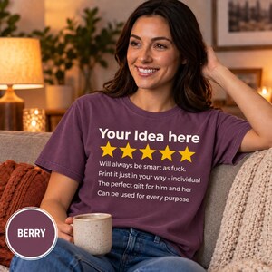 Woman with a coffee mug on a cozy couch wearing the personalized golden 5-star review T-shirt by SarcasmArt in Berry – a personalized gift for her.