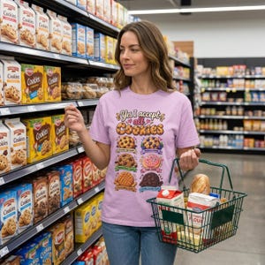Woman shopping in a grocery store aisle wearing the "Yes, I Accept All Cookies" funny programmer T-shirt by SarcasmArt in Orchid (soft lilac).