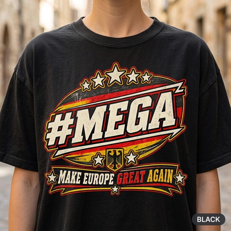 Close-up of the "#MEGA Make Europe Great Again" Germany T-shirt by SarcasmArt in Black: a retro #MEGA sports badge with black-red-gold German flag stripes, a German eagle shield, stars and a MAKE EUROPE GREAT AGAIN banner with GREAT in red, printed large on a garment-dyed Comfort Colors 1717 tee.
