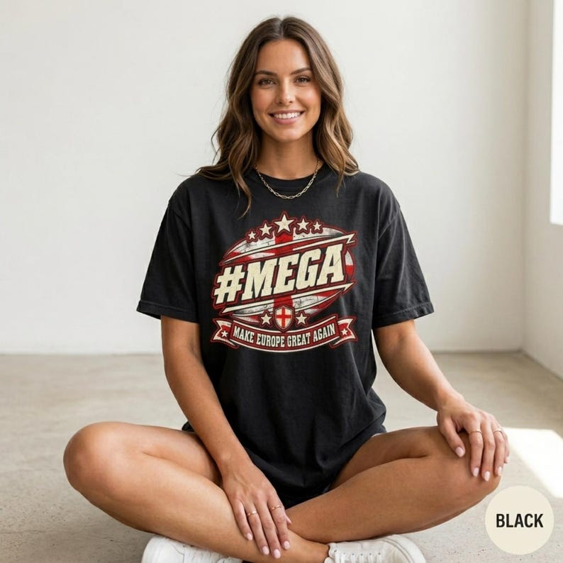 Smiling woman sitting cross-legged in a bright studio wearing the "#MEGA Make Europe Great Again" England T-shirt by SarcasmArt in Black.