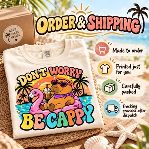 Order and shipping for the "Don't Worry Be Cappy" capybara beach T-shirt by SarcasmArt: made to order, printed just for you, carefully packed and tracking provided after dispatch.