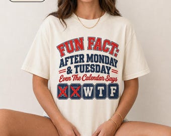 May include: An ivory short-sleeve t-shirt featuring red and navy blue text that reads: FUN FACT: AFTER MONDAY & TUESDAY Even The Calendar Says W T F. The letters W, T, and F are enclosed in navy blue boxes, while the letters M and T are crossed out.