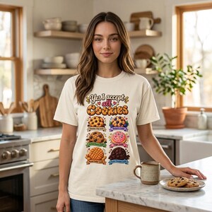 Woman in a cozy kitchen wearing the "Yes, I Accept All Cookies" funny programmer T-shirt by SarcasmArt in Ivory.