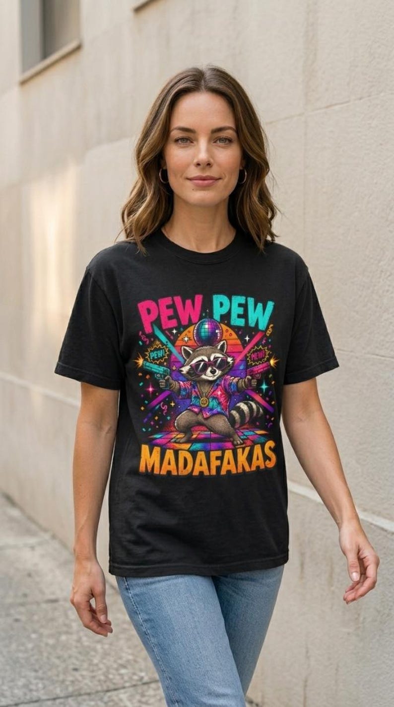 Woman in jeans wearing the "Pew Pew Madafakas" raccoon meme T-shirt by SarcasmArt in Black.