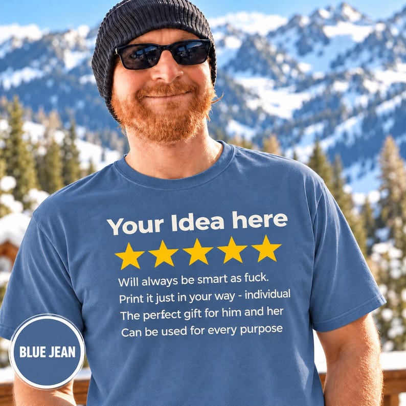 Bearded man in a beanie and sunglasses in front of snowy mountains wearing the personalized golden 5-star review T-shirt by SarcasmArt in Blue Jean, with your custom title, five golden stars and four lines of your own review text in white.