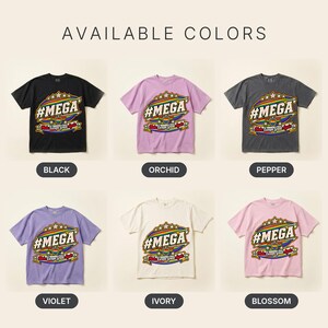 Available colors of the "#MEGA Make Europe Great Again" Rainbow Pride T-shirt by SarcasmArt: Black, Orchid, Pepper, Violet, Ivory and Blossom, all with the same #MEGA badge print.