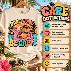 Care instructions for the "Don't Worry Be Cappy" capybara beach T-shirt by SarcasmArt: machine wash cold, wash inside out with similar colors, do not bleach, tumble dry low, do not iron directly on the print, do not dry clean.