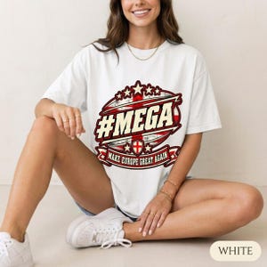 Woman sitting on the floor in a bright studio wearing the "#MEGA Make Europe Great Again" England T-shirt by SarcasmArt in White.