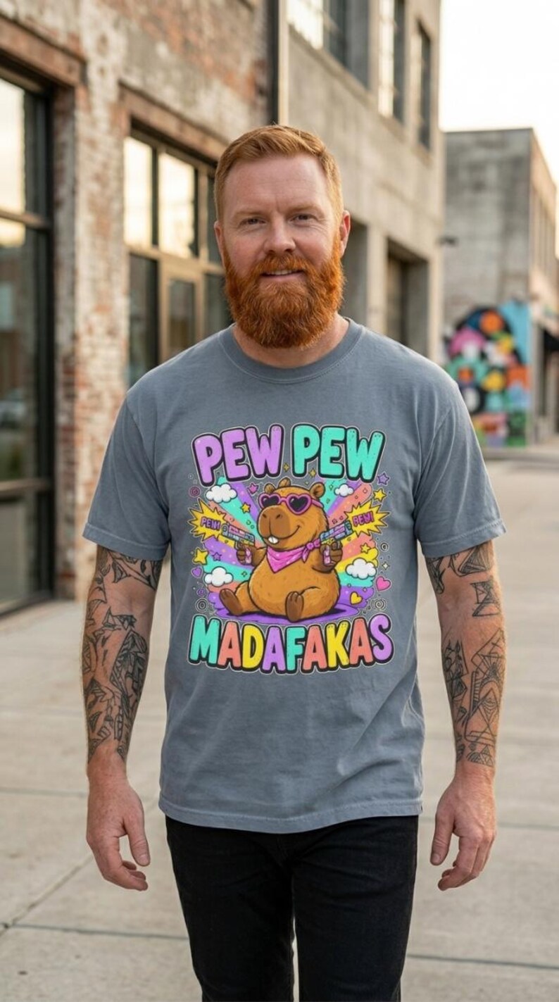 Bearded man on a city street wearing the "Pew Pew Madafakas" capybara meme T-shirt by SarcasmArt in Blue Jean.