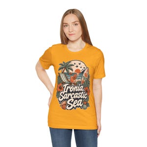 Woman in jeans wearing the "Ironia, Sarcastic Sea" retro beach T-shirt by SarcasmArt in golden yellow – a sarcastic beach and pool day shirt.