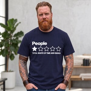 Bearded man wearing the "People – 1 Star, Total Waste of Time and Energy" sarcastic review T-shirt by SarcasmArt in True Navy, a minimalist sarcastic shirt.
