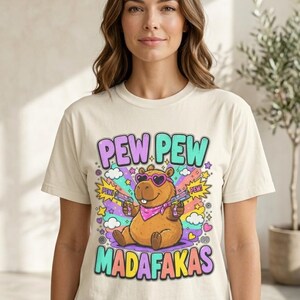 Woman in jeans wearing the "Pew Pew Madafakas" capybara meme T-shirt by SarcasmArt in Ivory.