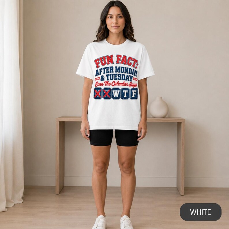 Woman in shorts wearing the "Fun Fact: After Monday & Tuesday" WTF varsity work T-shirt by SarcasmArt in White – full-length view of the relaxed unisex fit.