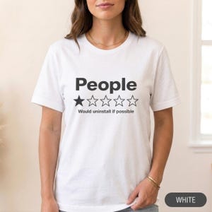 Woman wearing the "People – 1 Star, Would Uninstall If Possible" funny review T-shirt by SarcasmArt in White, a minimalist sarcastic introvert shirt.