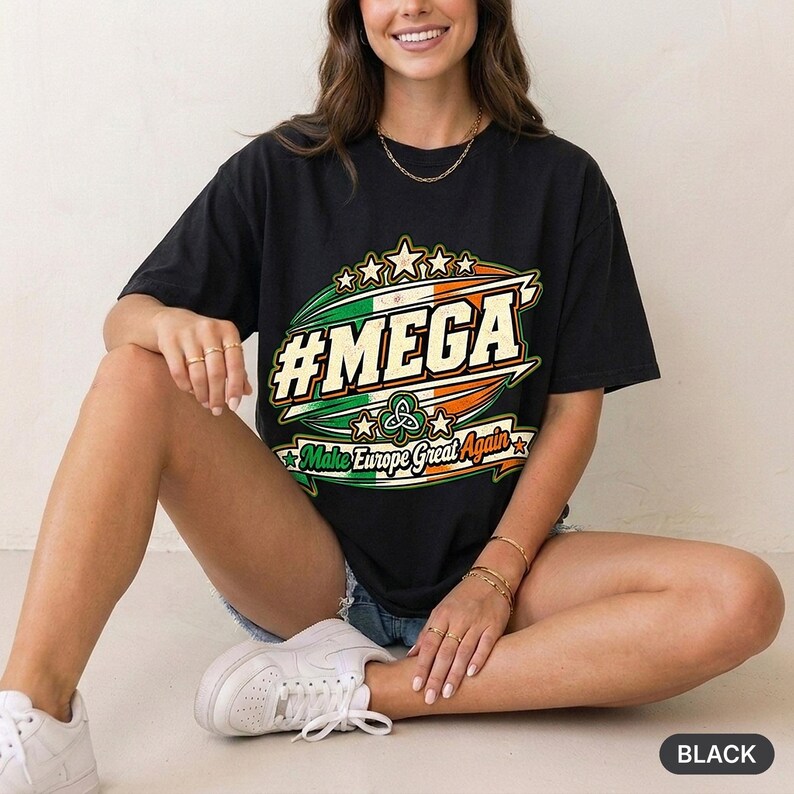 Woman sitting on the floor in a bright studio wearing the "#MEGA Make Europe Great Again" Ireland T-shirt by SarcasmArt in Black.