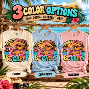 3 color options of the "Don't Worry Be Cappy" capybara beach T-shirt by SarcasmArt: Ivory, Chambray and Blossom – same design, different vibes.