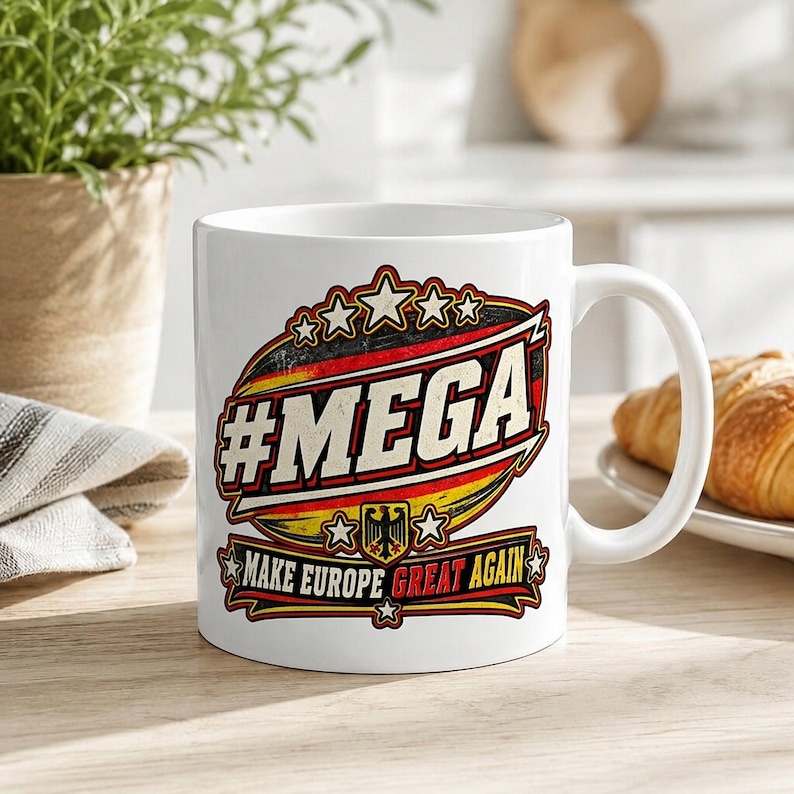The "#MEGA Make Europe Great Again" Germany coffee mug by SarcasmArt on a bright desk with notebooks – a funny political gift for friends and family with Germany roots.
