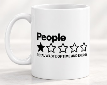 Op de afbeelding: Een witte keramische mok met zwarte tekst die People leest, gevolgd door één ingevulde zwarte ster en vier lege steromtrekken, met de tekst TOTAL WASTE OF TIME AND ENERGY in zwarte hoofdletters onder de sterren gedrukt.