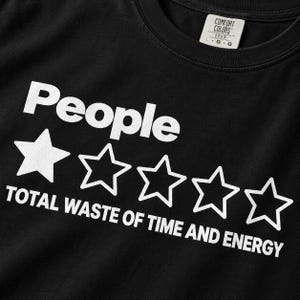 Close-up of the white one-star People review print on the Black "People – 1 Star, Total Waste of Time and Energy" sarcastic review T-shirt by SarcasmArt.